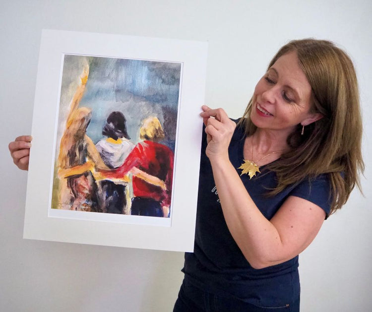 Artist Ingela Johansson holding her artprint with three friends titled "Women, life and freedom"