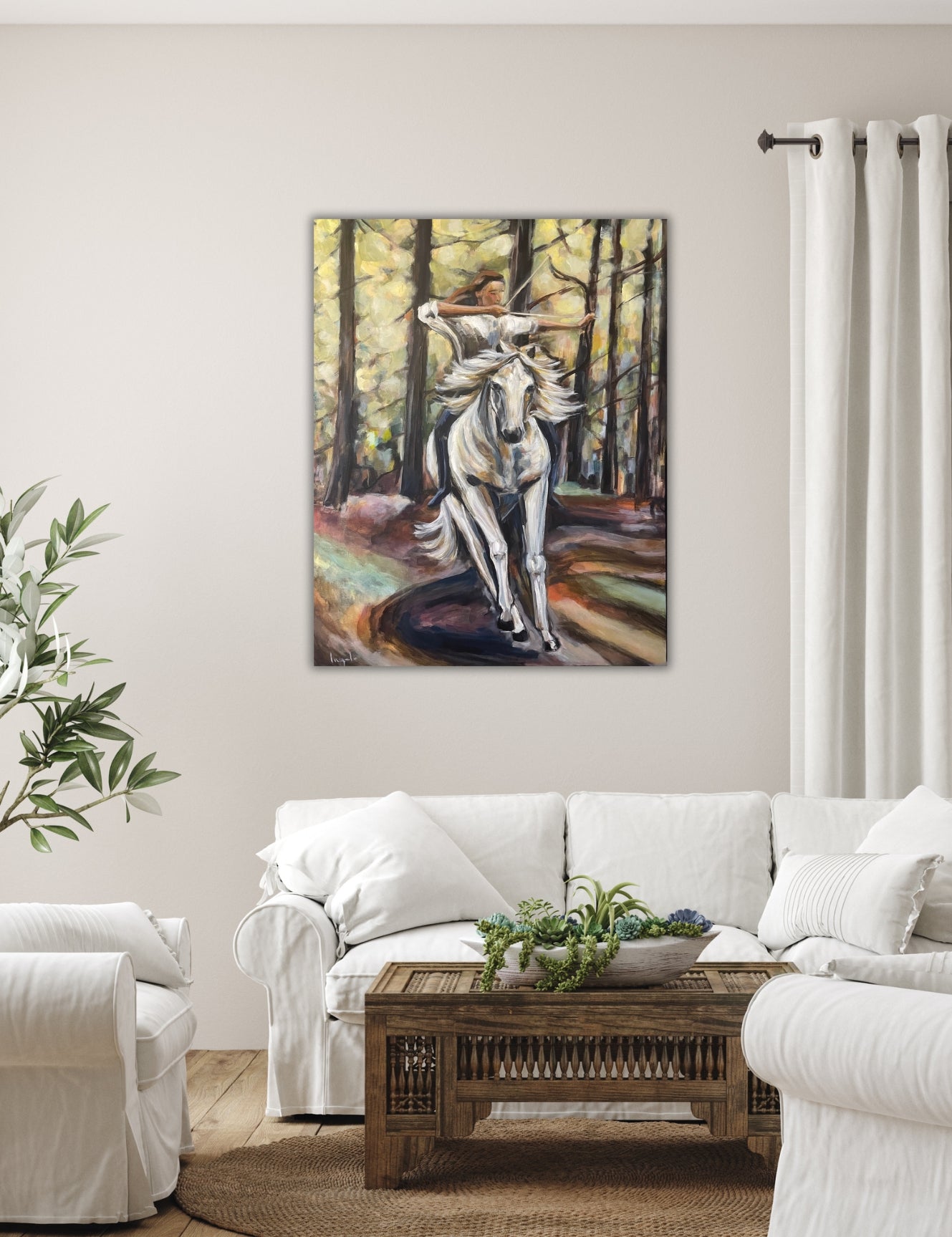 Original artwork ‘Power’ by Ingela Johansson displayed in a modern Scandinavian living room with white sofa, showing a dynamic woman riding a white horse in the forest.