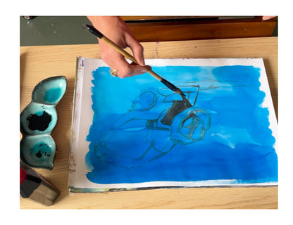 Artist Ingela Johansson painting Blue Tango in her studio using black ink on blue background – part of the Dance Collection.