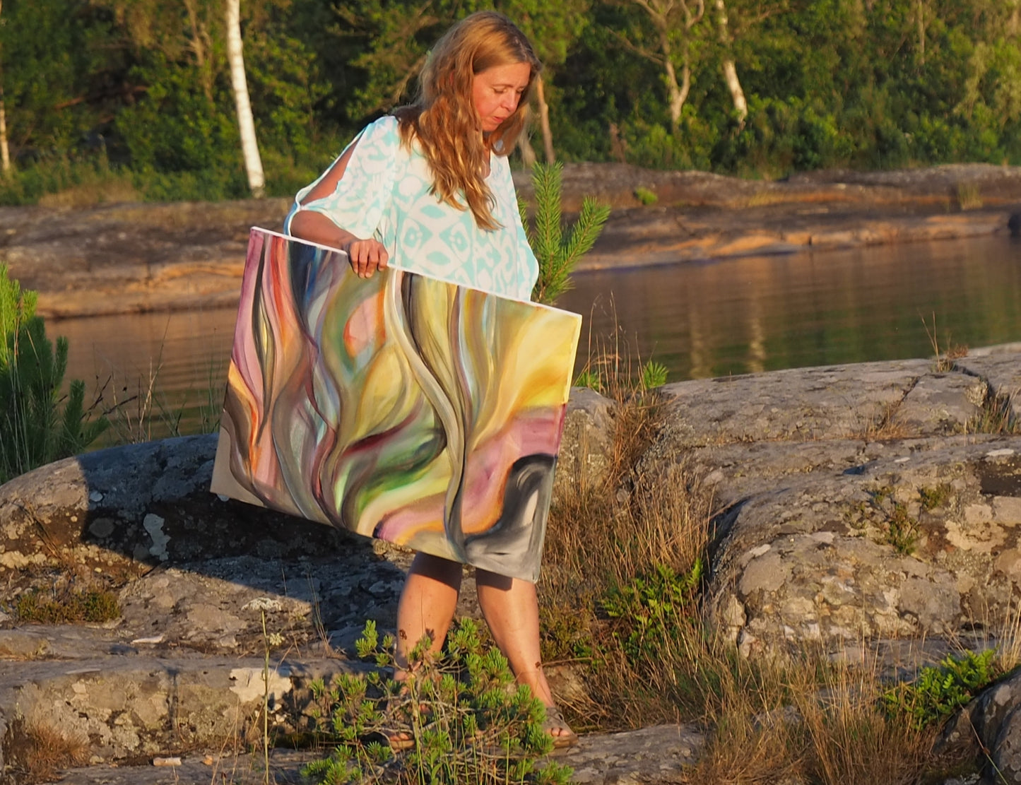 Artist Ingela Johansson with her abstract soft painting Sunset Currents photographe d in the sunset 